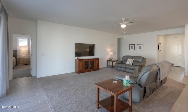 living area featuring light carpet and ceiling fan