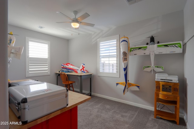 carpeted home office featuring plenty of natural light, visible vents, baseboards, and a ceiling fan