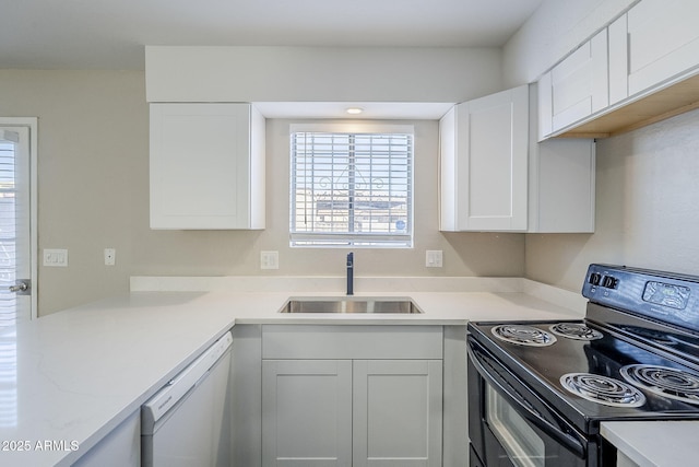 kitchen featuring white dishwasher, white cabinets, electric range, and sink