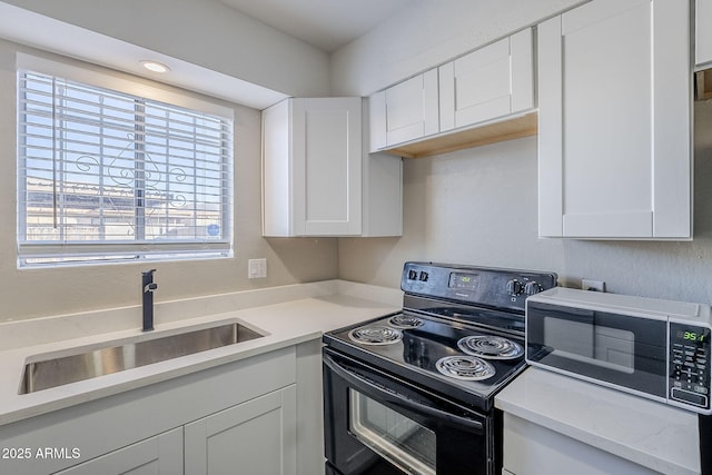 kitchen featuring sink, black range with electric cooktop, and white cabinetry