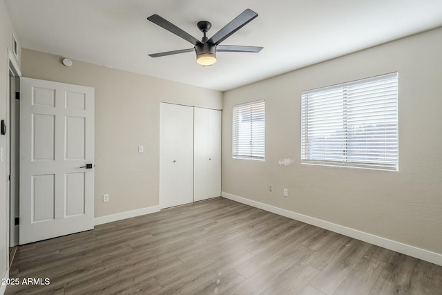 unfurnished bedroom with ceiling fan, a closet, and light hardwood / wood-style floors