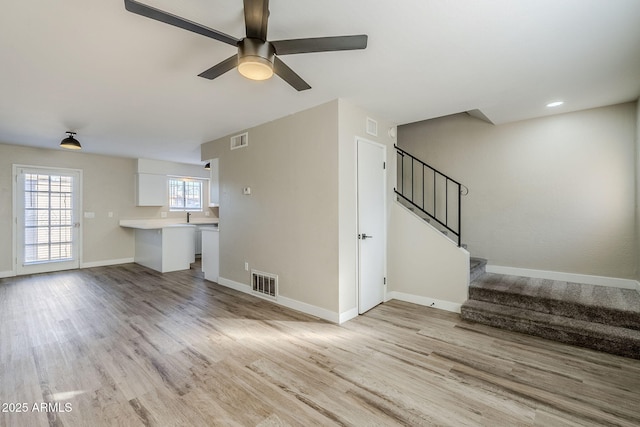 unfurnished living room with ceiling fan and light hardwood / wood-style flooring