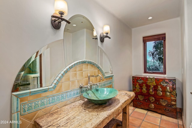 interior space featuring backsplash, vanity with extensive cabinet space, and tile flooring