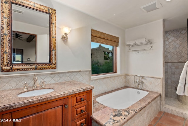 bathroom featuring vanity, ceiling fan, tile walls, tile floors, and tiled tub