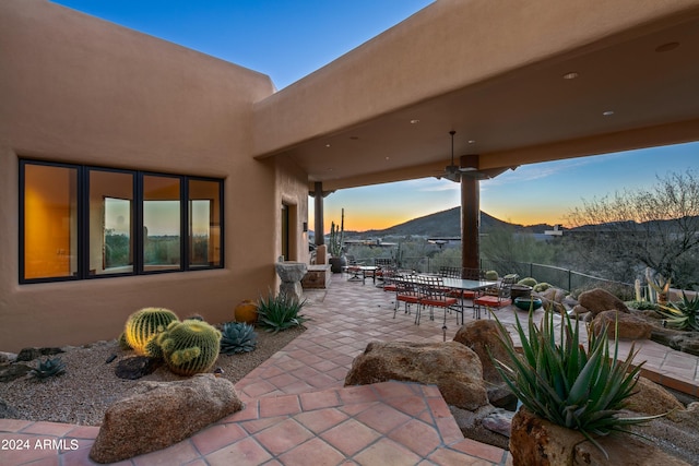 patio terrace at dusk featuring ceiling fan