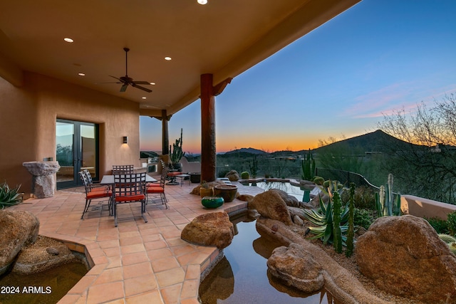 patio terrace at dusk featuring ceiling fan