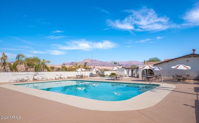 view of pool featuring a mountain view and a patio area