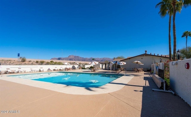 view of pool with a mountain view and a patio