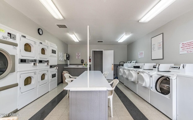 clothes washing area with stacked washer and dryer and washing machine and clothes dryer