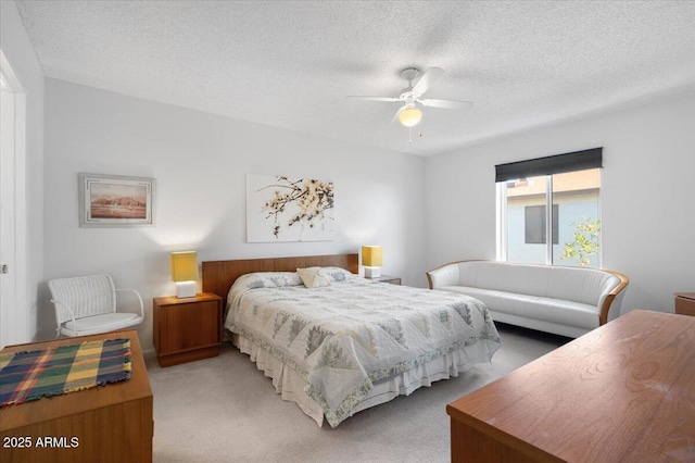 bedroom featuring carpet flooring, a textured ceiling, and ceiling fan