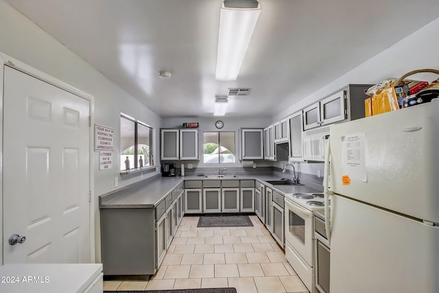 kitchen featuring gray cabinets, white appliances, sink, and light tile patterned floors