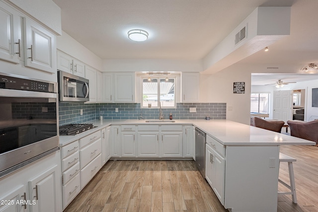 310 E Fremont Dr, Tempe, AZ 85282 - kitchen featuring appliances with stainless steel finishes, a peninsula, a kitchen bar, a sink, and open floor plan
