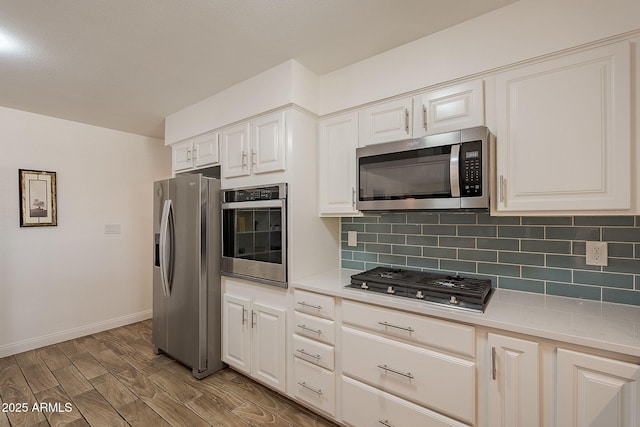 310 E Fremont Dr, Tempe, AZ 85282 - kitchen featuring appliances with stainless steel finishes, decorative backsplash, light countertops, and light wood-style flooring