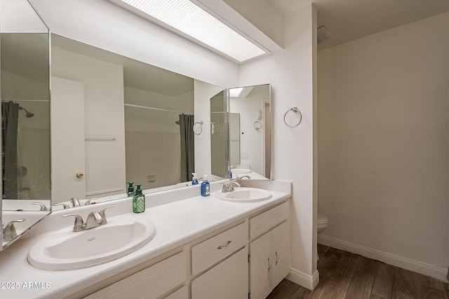 310 E Fremont Dr, Tempe, AZ 85282 - full bathroom with toilet, double vanity, wood finished floors, a tile shower, and baseboards