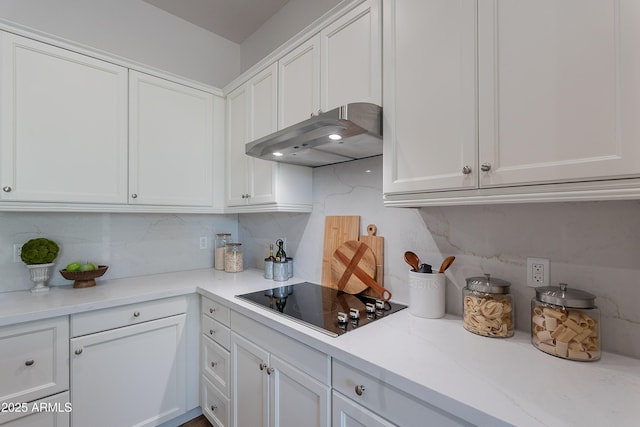 kitchen featuring black electric stovetop, under cabinet range hood, and white cabinetry