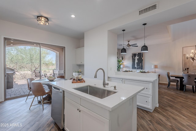 kitchen featuring a sink, dark wood-style floors, an island with sink, dishwasher, and white cabinetry
