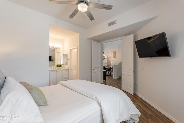 bedroom featuring dark wood-type flooring, baseboards, connected bathroom, and a ceiling fan