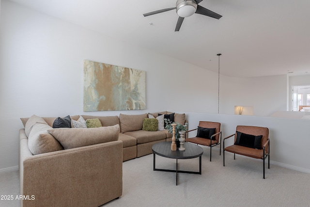 living area with a ceiling fan, baseboards, and light carpet