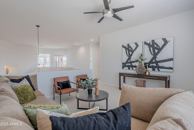 living area featuring light colored carpet, a ceiling fan, baseboards, and recessed lighting