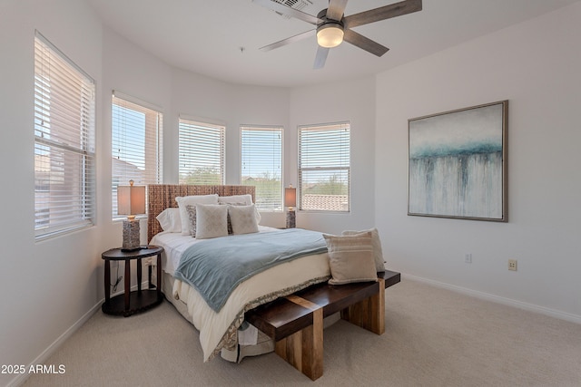 bedroom with multiple windows, light colored carpet, and baseboards
