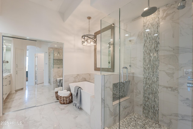 bathroom featuring a stall shower, a soaking tub, vanity, and marble tiled flooring