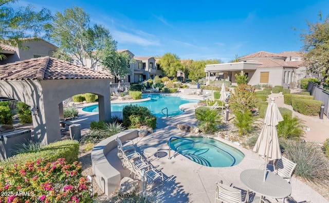 community pool featuring a hot tub and a patio