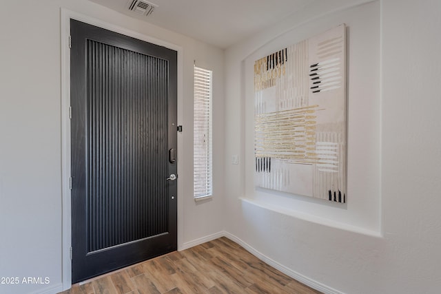 foyer entrance with wood finished floors and baseboards