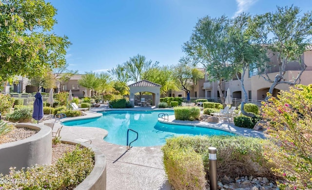 community pool with a gazebo, a patio area, and a residential view