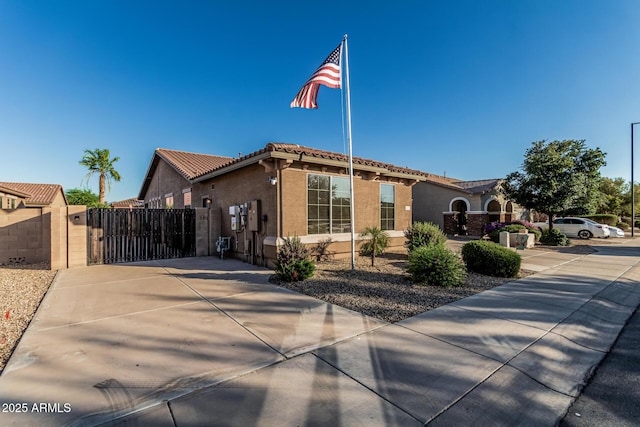 16077 W Anasazi St, Goodyear, AZ 85338 - mediterranean / spanish house featuring a gate, stucco siding, driveway, and a tiled roof
