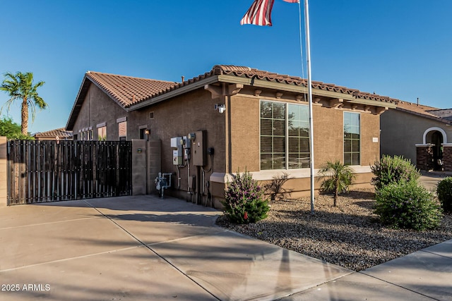 16077 W Anasazi St, Goodyear, AZ 85338 - view of home's exterior with stucco siding, a gate, driveway, and a tile roof