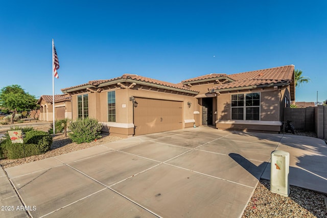 16077 W Anasazi St, Goodyear, AZ 85338 - mediterranean / spanish house featuring stucco siding, a tiled roof, concrete driveway, and an attached garage