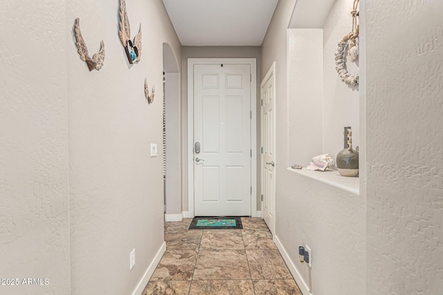 16077 W Anasazi St, Goodyear, AZ 85338 - entryway with arched walkways, stone finish flooring, and a textured wall