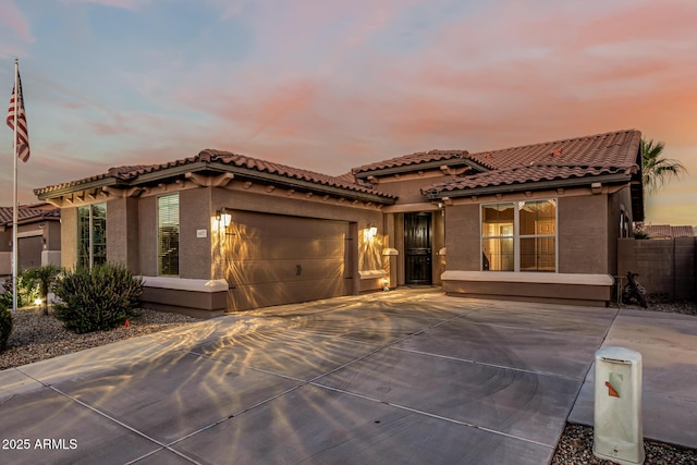 16077 W Anasazi St, Goodyear, AZ 85338 - mediterranean / spanish home with stucco siding, an attached garage, a tile roof, and driveway