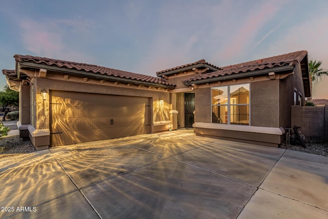 16077 W Anasazi St, Goodyear, AZ 85338 - mediterranean / spanish-style house featuring concrete driveway, a garage, stucco siding, and a tile roof