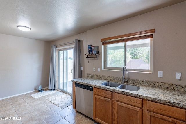 kitchen featuring light stone countertops, dishwasher, a textured ceiling, and sink