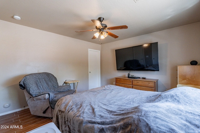 bedroom with dark hardwood / wood-style flooring and ceiling fan