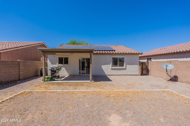 back of house featuring solar panels, a patio area, and central AC