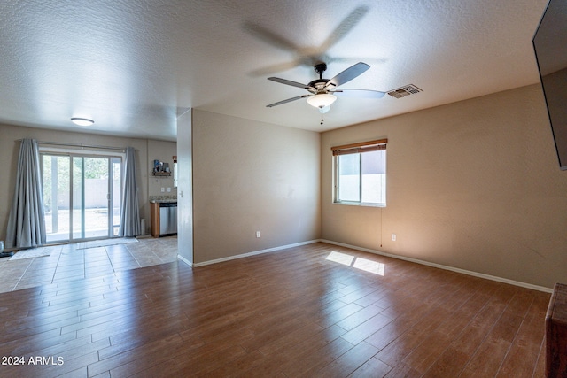 empty room featuring ceiling fan, a textured ceiling, and wood-type flooring