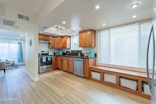 kitchen with appliances with stainless steel finishes, light hardwood / wood-style floors, and sink