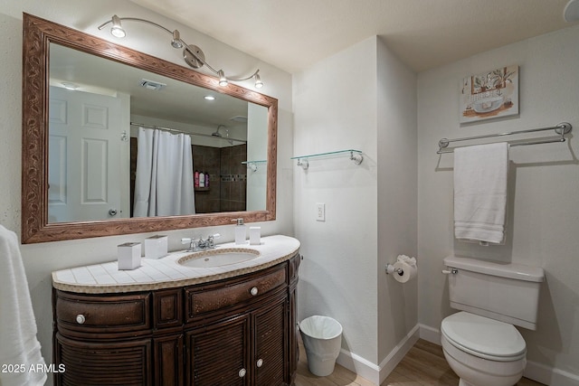 bathroom featuring hardwood / wood-style flooring, vanity, curtained shower, and toilet