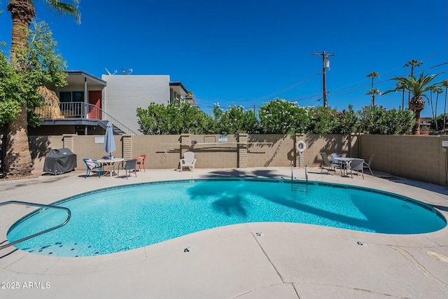 view of swimming pool featuring grilling area and a patio