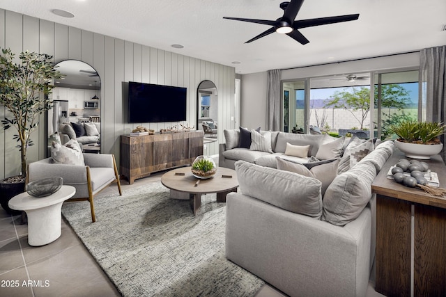 living area featuring ceiling fan and arched walkways