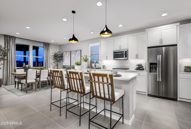 kitchen with appliances with stainless steel finishes, light tile patterned floors, backsplash, light countertops, and recessed lighting