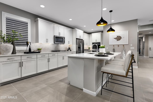 kitchen featuring stainless steel appliances, a sink, tasteful backsplash, light countertops, and light tile patterned floors