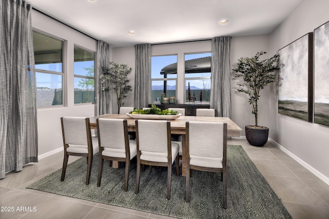 tiled dining space with baseboards and recessed lighting