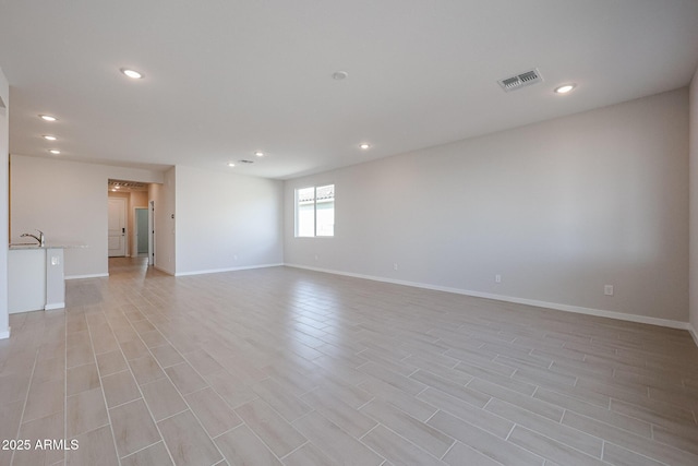 empty room featuring sink and light hardwood / wood-style flooring