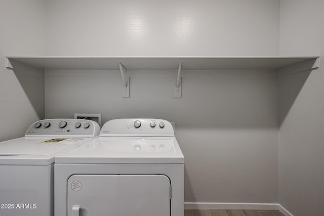 washroom with wood-type flooring and independent washer and dryer