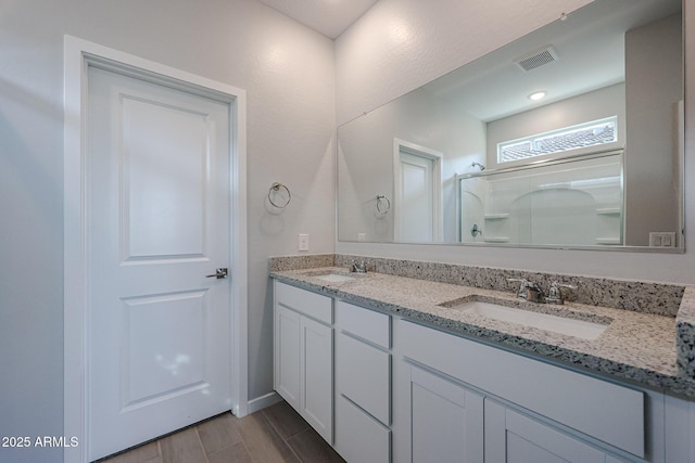 bathroom featuring vanity and a shower with shower door