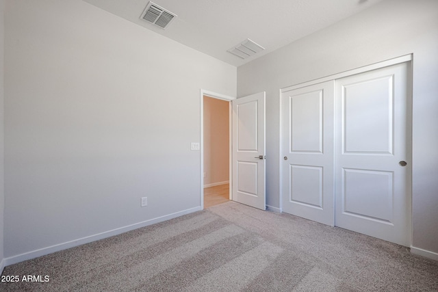 unfurnished bedroom featuring light colored carpet and a closet