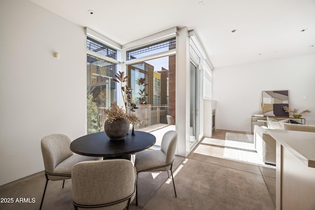 dining room featuring floor to ceiling windows and concrete floors